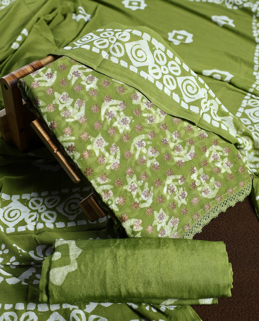 Light green colour churidhar material adorned with gold and copper toned floral patterns and bold block designs, paired with a plain matching bottom and stylish dupatta, perfect for festive evenings and traditional gatherings.