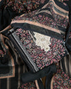 Black colour churidhar set featuring floral prints in pink, teal & beige, paired with plain black bottom and matching dupatta adorned with elegant embroidery.