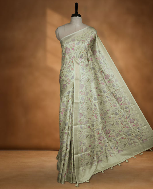 Light green colour semi tussar silk saree featuring all over floral and leaf motifs on the body with a subtle self border and tasselled pallu, paired with a matching blouse.
