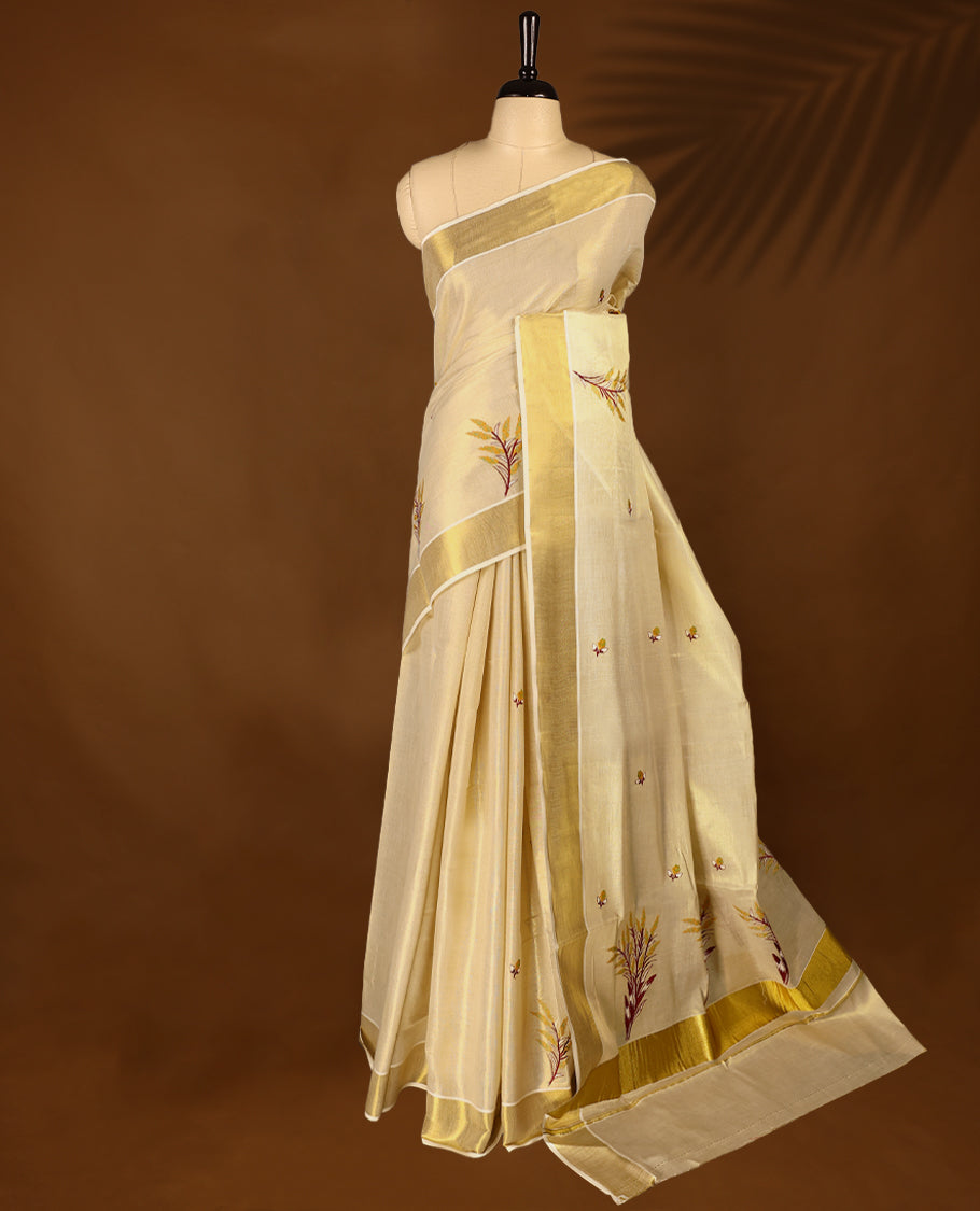 Light Gold colour Tissue Kerala saree featuring nell Kthir embroidery motifs on the body and a beautifully woven Gold Kasavu border, paired with a matching blouse perfect for festive occasions.