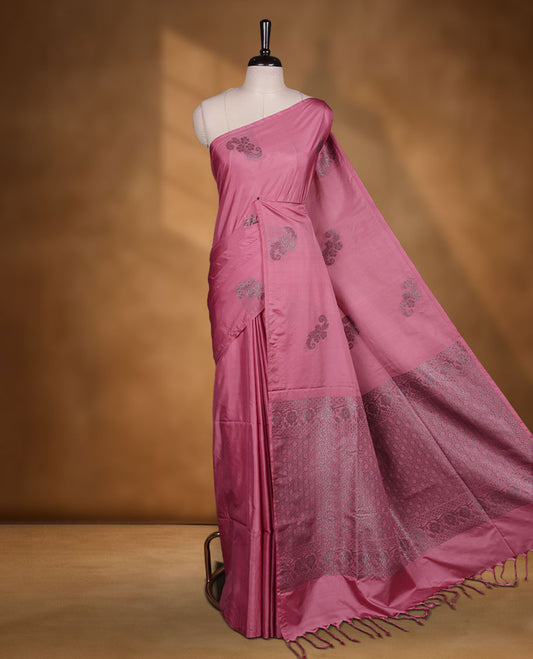 Pink colour semi soft silk saree adorned with delicate woven floral motifs on the body, complemented by a Self colour woven pallu with intricate detailing and tassel accents without border & Comes with a matching blouse piece.