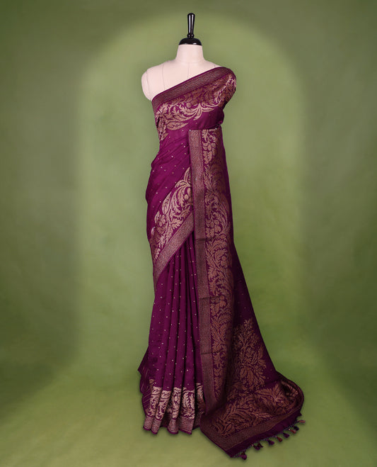 Grape wine colour Tussar Banaras saree adorned with delicate golden zari motifs on the body, rich floral woven zari border and grand pallu, paired with a matching blouse for an elegant and regal traditional look.