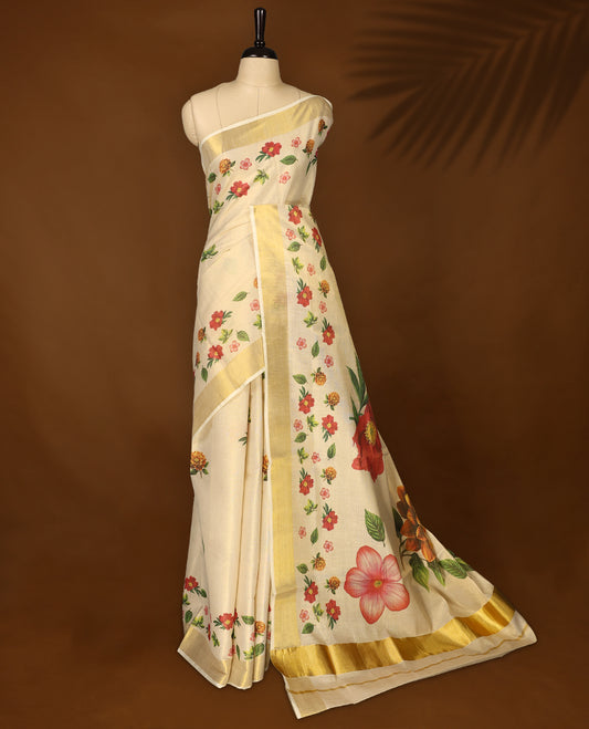 Elegant off white colour tissue Kerala saree with vibrant floral prints and a shimmering golden zari border, Lightweight and graceful, perfect for festive or traditional occasions & Includes matching blouse piece.