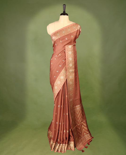 Pastel Brown colour pure Banaras crepe saree showcases elegant silver zari Flower Motifs all over the body, a traditional Banarasi gold zari border, a rich intricately woven pallu, and comes with a matching blouse.