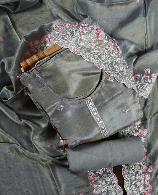 Grey colour churidar material adorned with delicate floral thread embroidery in white and pink, paired with a plain matching bottom and embroidered dupatta, perfect for festive occasions and celebrations.