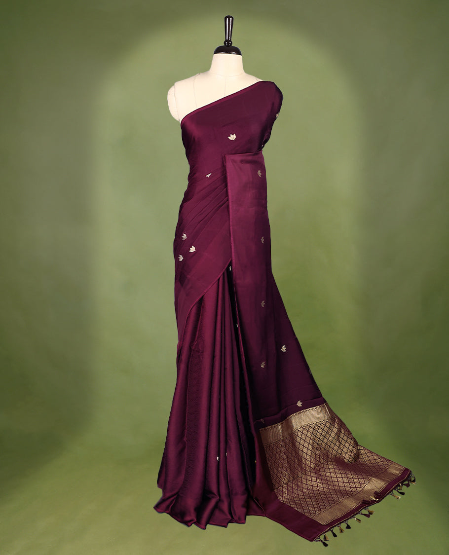 Maroon colour crepe Banaras saree featuring small zari Floral Motifs across the body, without border, a sleek texture, and a rich golden zari pallu with geometric patterns, paired with a matching blouse for a graceful festive look