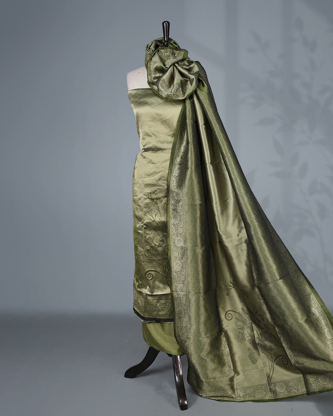 Green colour Tissue Salwar Material featuring subtle lotus floral motifs On Body ,paired with a matching bottom & graceful shaded Dupatta.