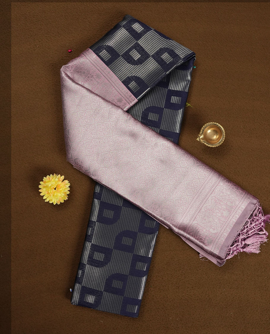 Navy blue colour semi silk saree adorned with silver zari motifs on the body, complemented by a pastel pink pallu intricately woven with rich floral patterns border and pallu, and paired with a matching blouse