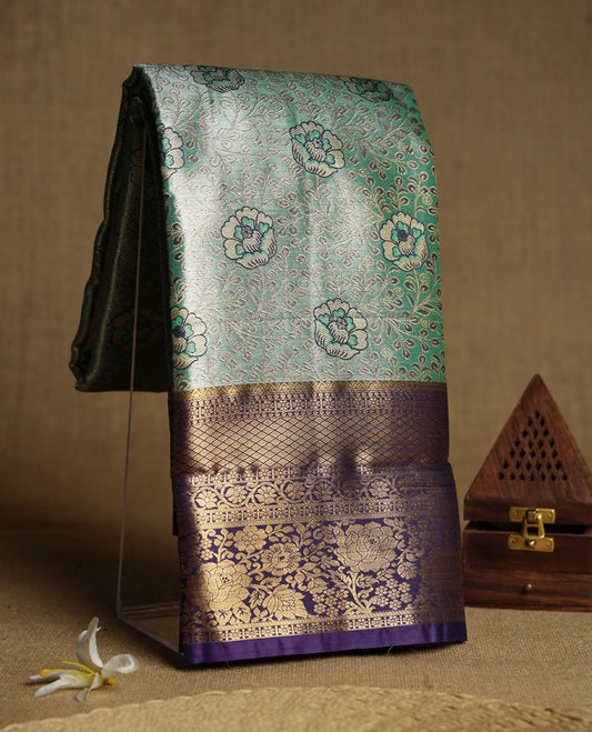 Aqua green colour and antique gold Zari Tissue Brocade Saree features intricate floral Motifs on body and rich Violet colour with traditioal Border & pallu with Gold Zari Patterns paired with matching blouse