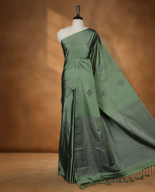 Maple green colour semi soft silk saree adorned with delicate woven motifs on the body, complemented by a Self colour woven pallu with intricate detailing and tassel accents without border & Comes with a matching blouse piece.