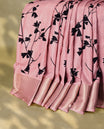 Pastel pink colour semi printed saree featuring black florak kodi prints across the body, finished with a Golden Zari border, with matching blouse
