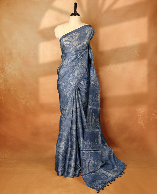 Blue colour pure tussar silk light weight saree with full body abstract floral print, no defined border and pallu, paired with matching abstract printed blouse.