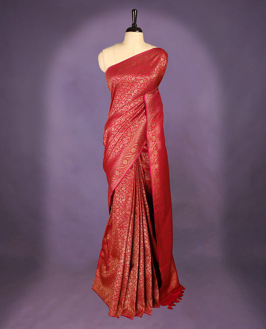 Rani pink colour semi Banaras Katan silk saree featuring intricate Antique Bronze zari floral and vine patterns woven throughout the body, enhanced with a rich traditional border and detailed pallu, paired with a matching blouse piece.