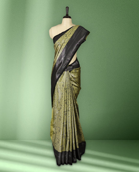 Pastel mustard green colour semi silk saree featuring neem zari floral kodi motifs all over the body, complemented by a pure black woven border with geometric detailing, with matching blouse.