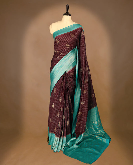 Dark Brown Colour semi Banaras georgette saree featuring golden Zari checks with double mango motifs on the body, complemented by an Aqua Blue traditional border and a matching blouse.