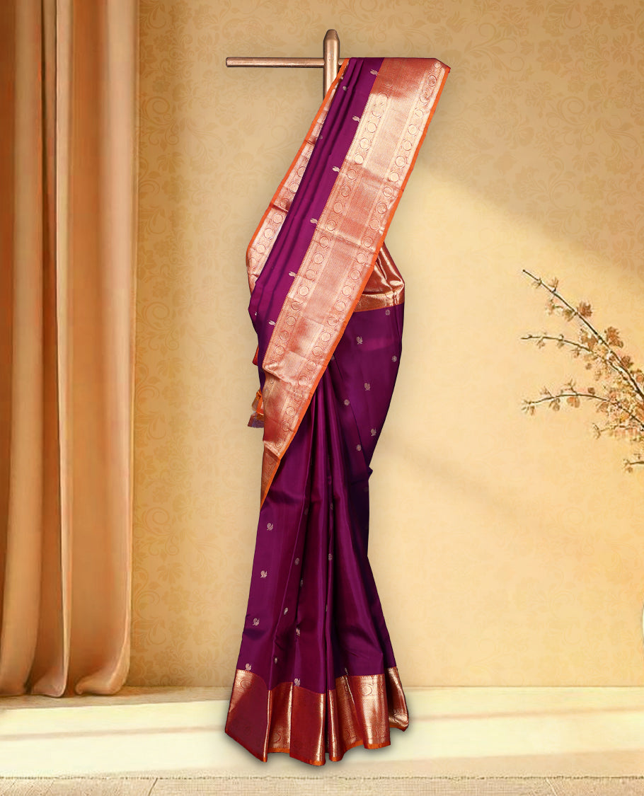Wine colour pure Kancheepuram saree with gold zari small Mayoora chackara motifs on the body traditional contrast border with floral kodi motifs grand gold zari woven pallu paired with contrast matching blouse