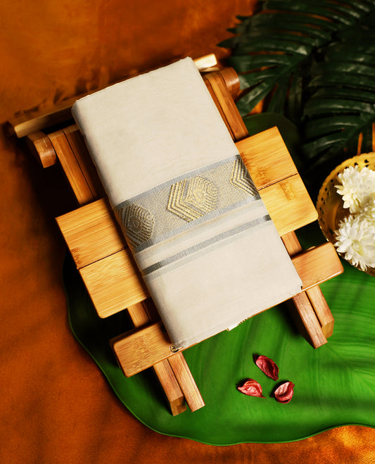 Off white colour pure handloom cotton dhoti featuring a silver zari border with golden woven motifs, crafted for traditional elegance, breathable comfort, and perfect for festive or cultural occasions.