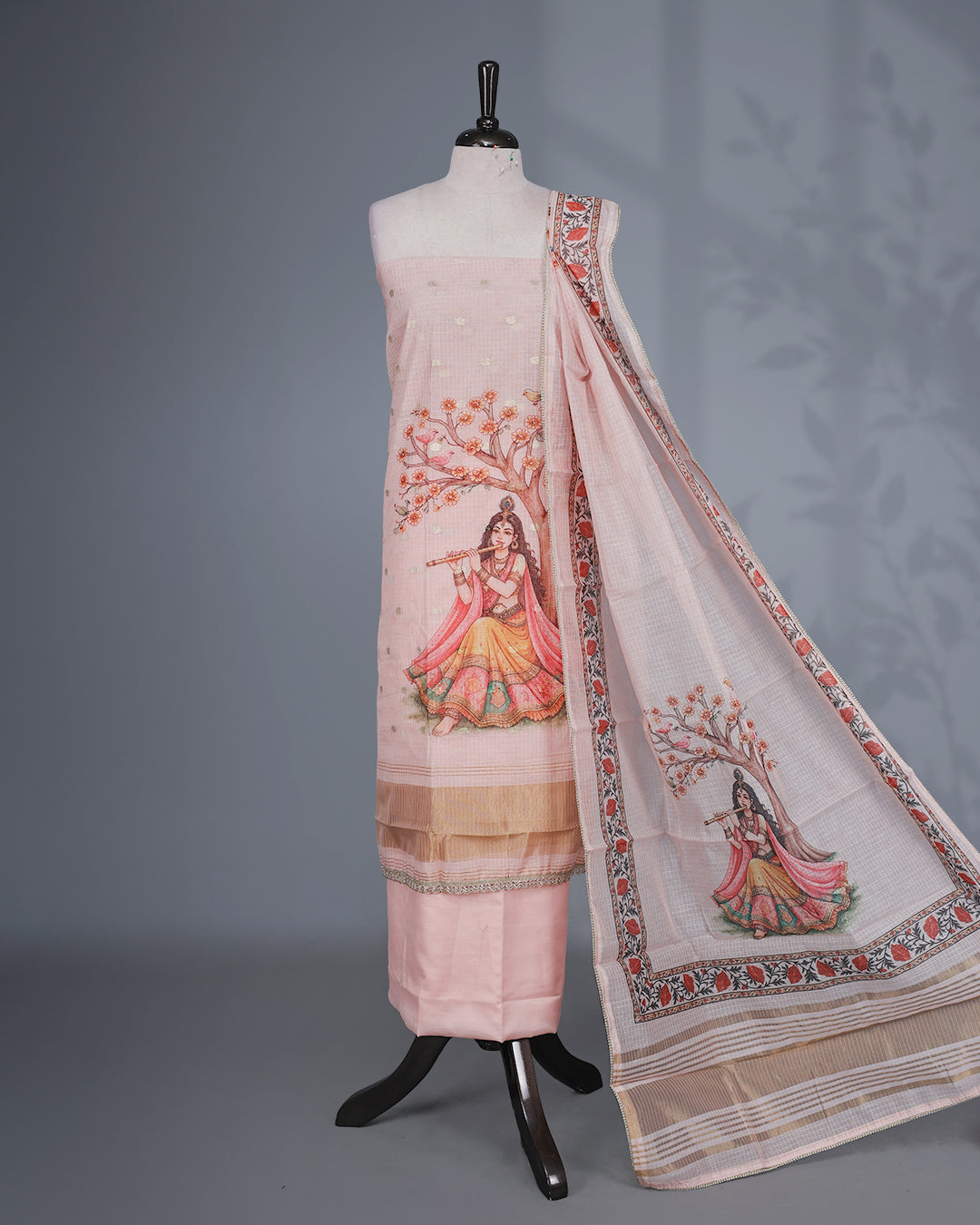 Light pink Colour Kotta Net Salwar material featuring a beautiful Radha inspired digital print with floral motifs and subtle golden accents on body , paired with a matching bottom and dupatta.