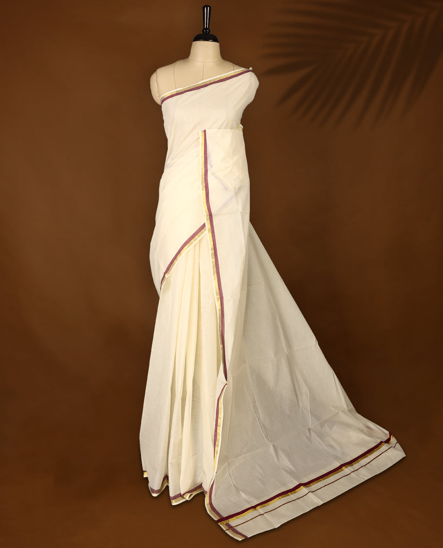 Elegant off white colour cotton Kerala saree featuring a plain body and traditional golden zari border with a hint of maroon, offering a classic and graceful look, paired with a matching blouse.