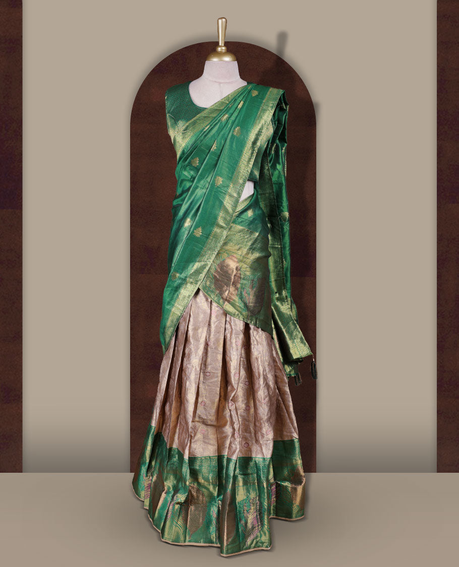 Gold and Green colour Dhavani set featuring a Gold colour skirt with contrast Green colour border with rich gold zari pattern, paired with a contrasting Green dupatta detailed with gold motifs