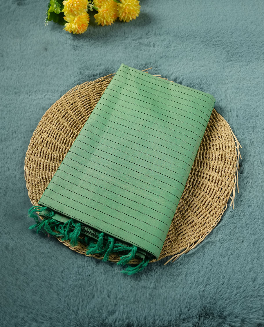 Pastel Green colour poly cotton saree with black vertical dotted line pattern on the body, paired with a matching pallu featuring black zigzag geometric border, and a coordinated all‑over black stylised fleur‑de‑lis printed blouse piece.