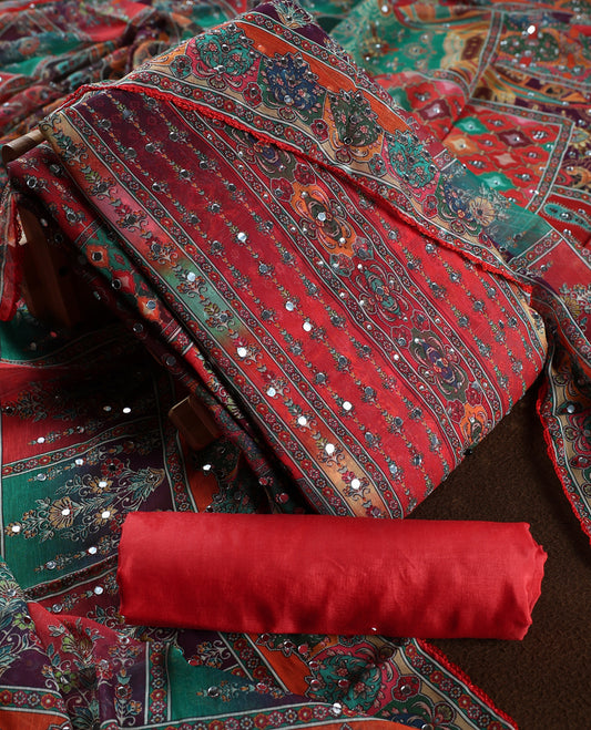 Red colour churidar material with rich floral and striped patterns enhanced by delicate mirror work, paired with a plain matching bottom and ornate dupatta.