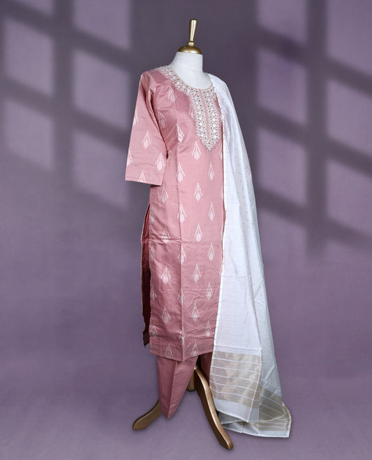 Dusty pink colour salwar set with ikat-inspired motifs and detailed mirror embroidery on the neckline, paired with plain bottom and an off white dupatta featuring golden striped detailing.