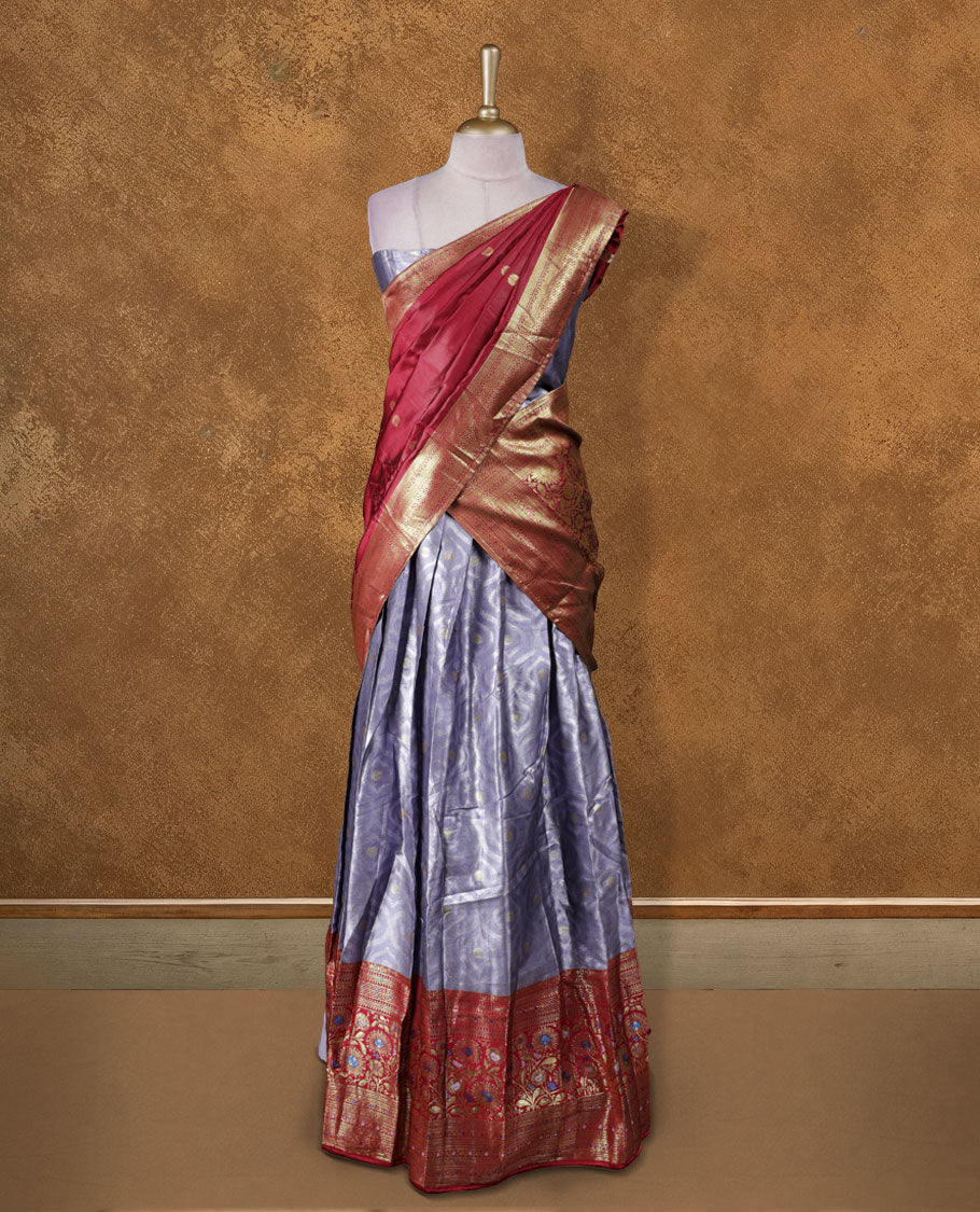 Charming Semi stitiched lavender and red Dhavani set featuring a lustrous lavender skirt with rich golden zari border, paired with a contrasting red dupatta detailed with golden motifs, perfect for festive and wedding occasions.