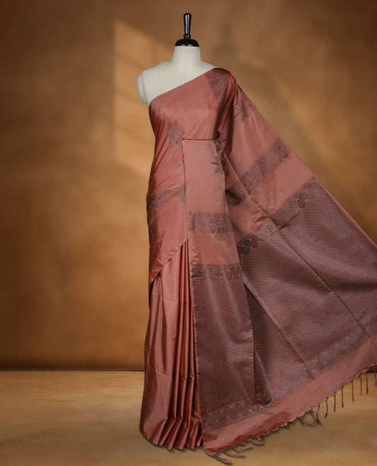 Brick colour semi soft silk saree adorned with delicate woven floral kodi motifs on the body, complemented by a Self colour woven pallu with intricate detailing and tassel accents without border & Comes with a matching blouse piece.