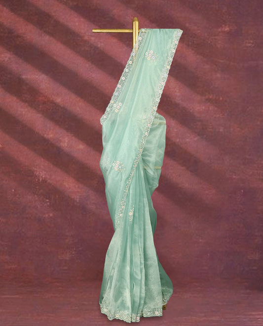 Aqua Green colour pure organza saree featuring all over floral sequin work, adorned with a matching intricately worked floral border, complemented by a richly embellished pallu and paired with a heavily worked matching blouse.