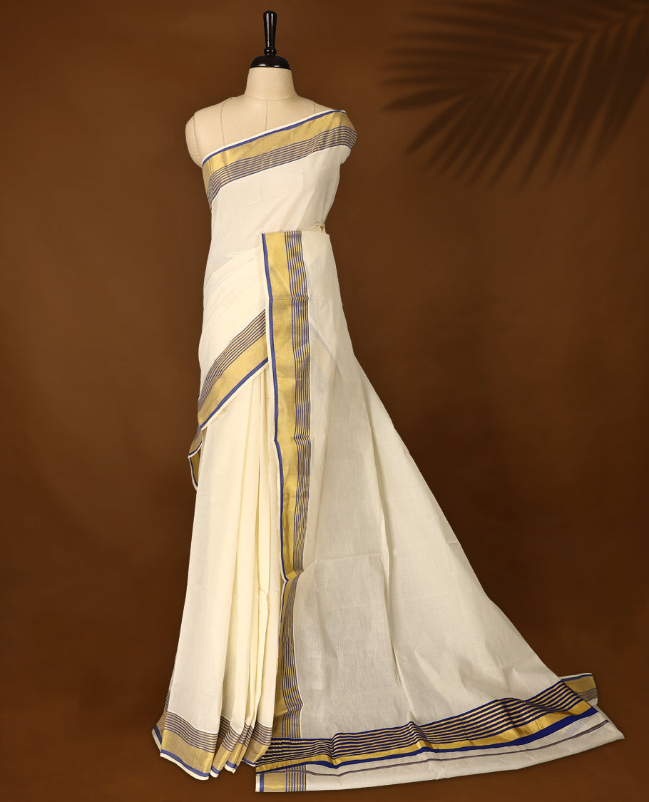 Elegant pure cotton Kerala saree with a cream base, golden zari border, and fine blue stripes & A perfect blend of tradition and simplicity, ideal for festive and cultural occasions and Paired with a matching blouse piece.