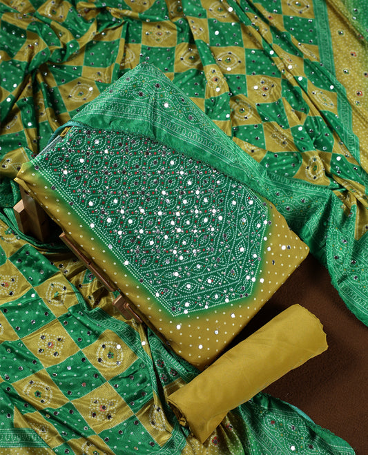 Lemon green colour churidhar material with intricate Bandhani style patterns and sparkling mirror work, Paired with a plain mustard bottom and a matching dupatta highlighted with mirror embellishments.