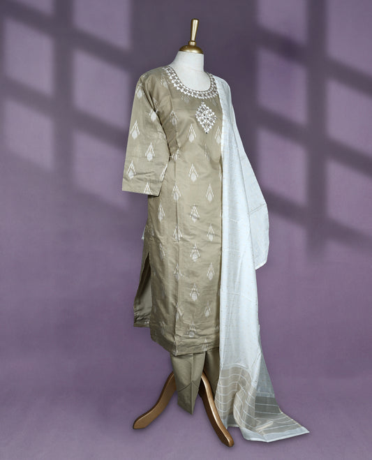 Light Khaki colour salwar set featuring ikat style motifs and delicate mirror work on the neckline, paired with matching plain bottom and an elegant off white dupatta with subtle golden thread detailing.