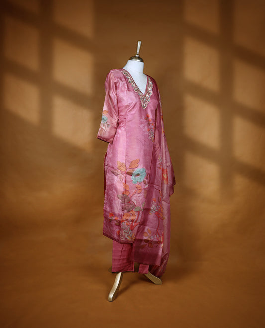 Pastel pink colour salwar from TWARA, featuring a V neck adorned with cut beads, beads, and thread work, with digital floral prints on the top, paired with a matching bottom and a digital printed dupatta.