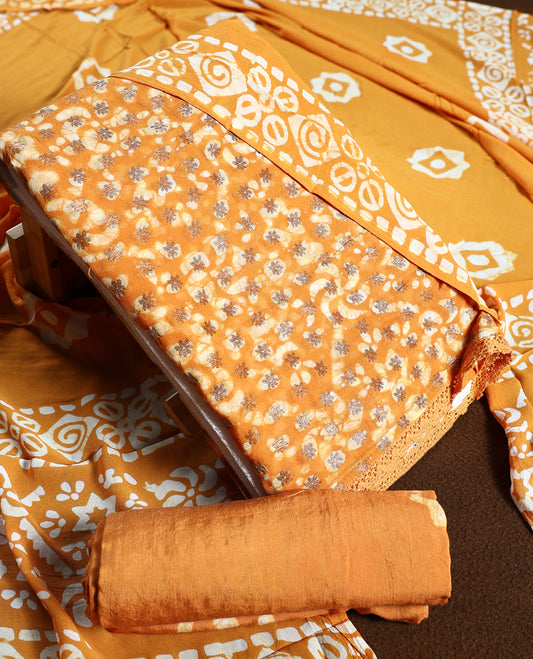 Deep yellow colour churidhar material featuring delicate floral patterns with gold highlights and bold block designs, paired with a plain matching bottom and vibrant dupatta.