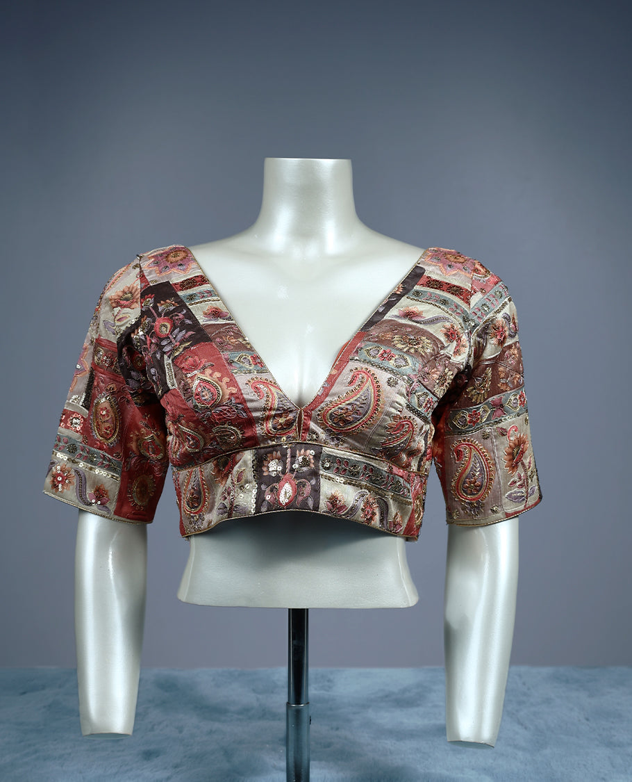 Multicolour patchwork designer padded readymad blouse featuring deep maroon, beige, and copper tones with paisley and floral motifs, crafted with elbow length sleeves and a deep V neckline.