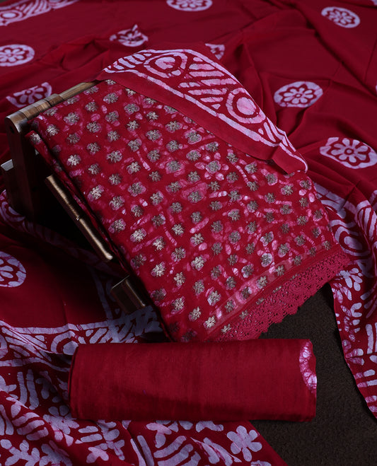 Maroon colour churidhar material adorned with gold and copper toned floral patterns and bold block designs, paired with a plain matching bottom and stylish dupatta, perfect for festive evenings and traditional gatherings.