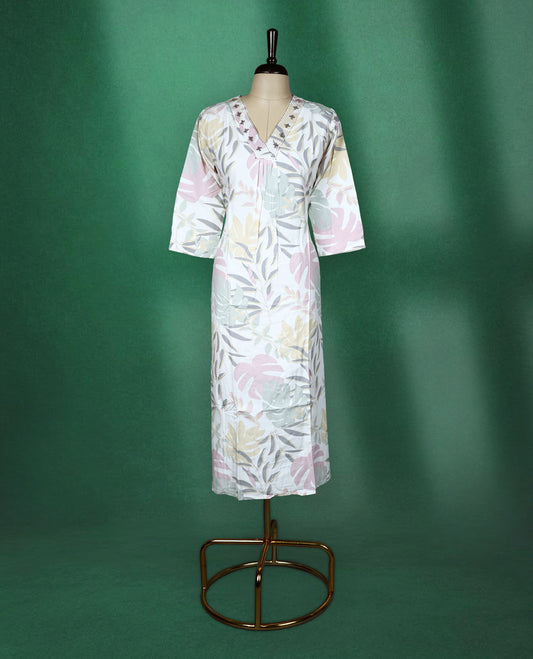 White colour kurti featuring pastel botanical prints in shades of pink, mint, and beige, designed with a V neckline embellished with delicate embroidery and finished with three quarter sleeves & soft, airy choice for effortless everyday wea