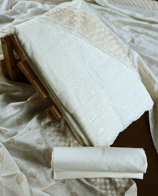 Elegant off white colour churidhar material featuring intricate woven patterns and subtle paisley embroidery, paired with a plain matching bottom and a delicately designed dupatta, perfect for timeless festive and traditional wear.