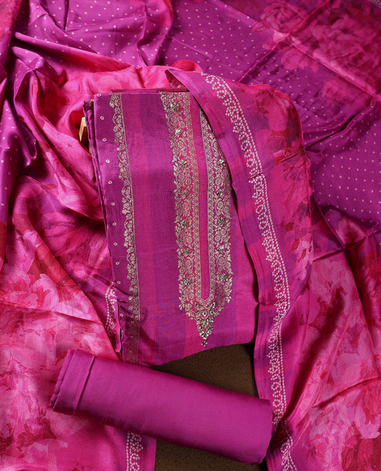 Radiant magenta colour churidhar material adorned with intricate zari embroidery on the neckline, paired with a plain bottom and a floral printed dupatta with dotted accents.