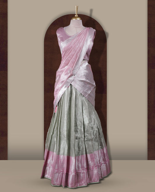 Light green and pink colour Dhavani set featuring a Light green colour skirt with contrast Pink colour border with rich silver zari pattern, paired with a contrasting Pink dupatta detailed with silver motifs