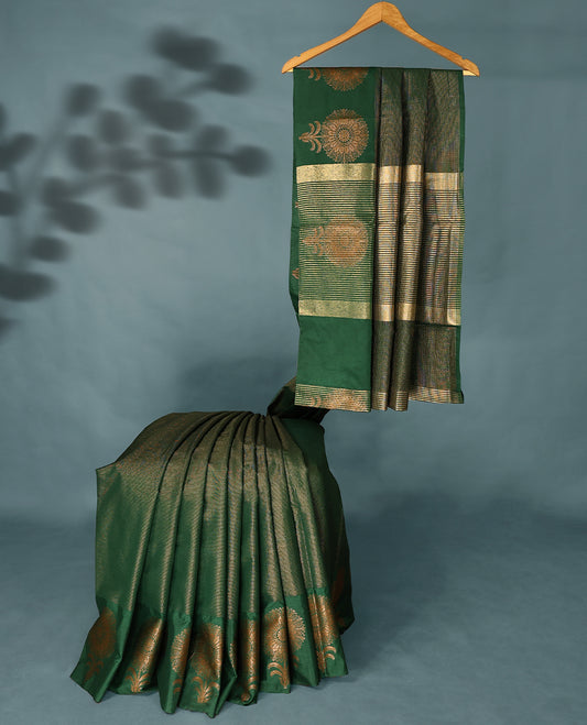 Bottle green Colour Semi Tussar Silk saree featuring golden zari horizontal lines across the body, adorned with bold floral motifs on the border, paired with a matching blouse.