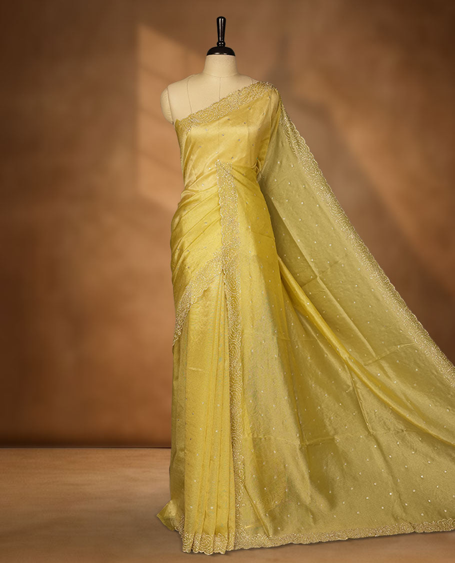 Golden olive colour net shimmer fancy saree adorned with white stone buttas, paired with a delicate stone worked border and matching blouse.