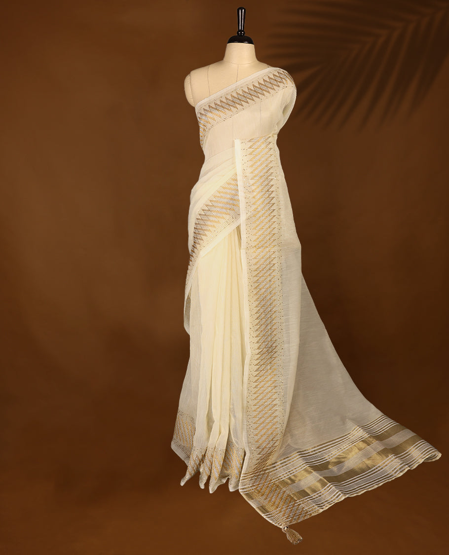 Ivory colour organza Kerala saree with golden zari detailing, featuring diagonal woven patterns on the pallu and border. Lightweight and elegant, it comes with a matching blouse piece for festive charm.