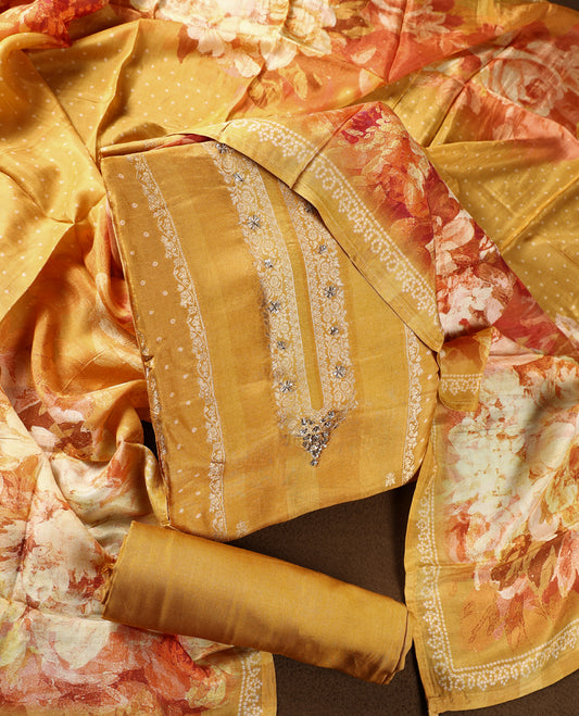 Mustard yellow colour churidhar material featuring delicate zari embroidery on the neckline, paired with a plain matching bottom and a floral printed dupatta with dotted patterns.