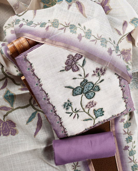 Beige & lavender colour churidhar material with floral print enhanced by sewn glass beads on the body, paired with plain lavender bottom & floral print dupatta.