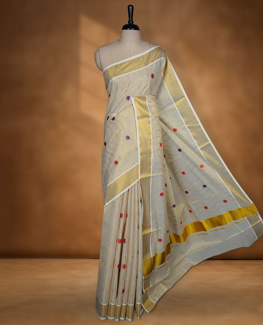 Off white colour cotton Kerala saree with wavy zari lines and colourful red and purple motifs, complemented by a classic golden zari border and matching blouse.
