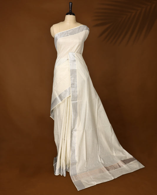 Elegant off white colour cotton Kerala saree featuring silver zari vertical stripes, sleek silver kasavu border & rich pallu, offering a timeless and graceful look and Pair with a matching blouse for festive elegance.
