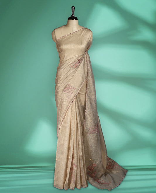 Beige gold colour organza designer saree featuring a subtle shimmer woven body with delicate green floral Soft mauve embroidery, scalloped thread detailing along the border and pallu paired with matching blouse.
