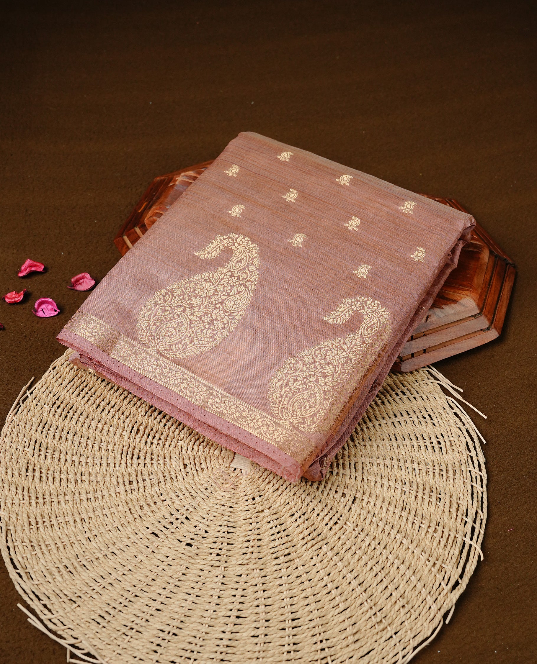 Salmon pink colour semi tussar silk saree featuring small gold zari mango motifs across the body, enhanced with a self colour border showcasing elegant gold zari mango patterns. Paired with a matching blouse piece.